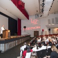 Ceremony stage with crowd of people in white coats