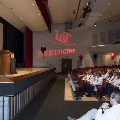 A woman in a white coat speaks at a podium