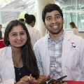 Two white coat clad students pose for a photo