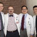 Four students in white coats pose for a photo
