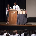 two speakers stand at podium